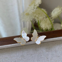 Iridescent Butterfly Shell Stud Earrings featuring luminous shell wings and delicate zirconia accents in a butterfly-inspired gold-tone design.