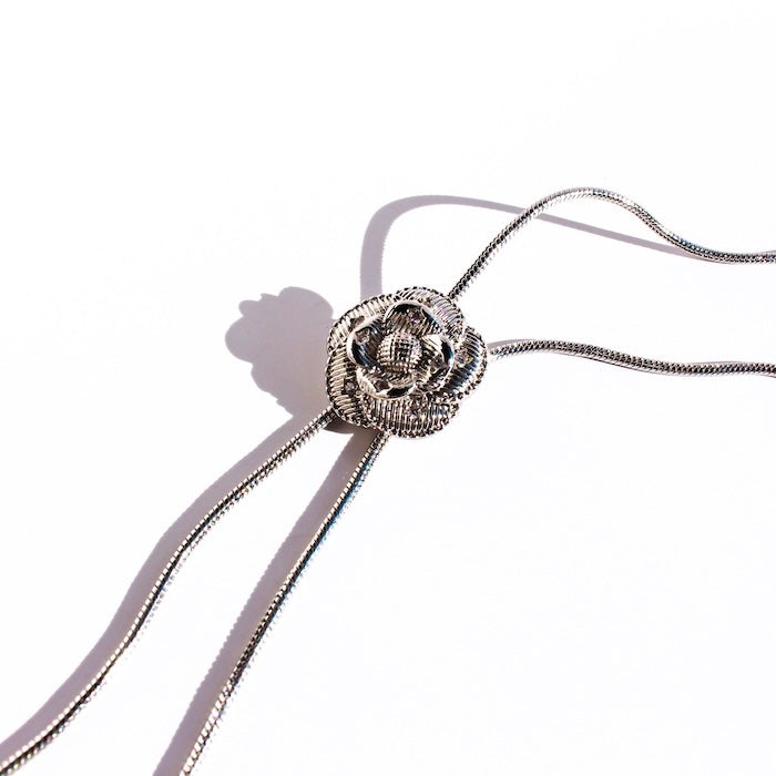 Sophisticated Silver Camellia Necklace and Earrings Set featuring delicate camellia-inspired floral details in a silver-plated finish with matching earrings.
