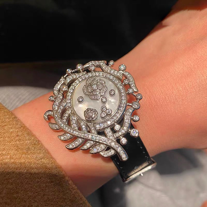 Camellia Convertible Watch Style Bracelet featuring a detachable mother-of-pearl and premium-grade zirconia centerpiece on a black PU leather strap with a luxurious watch-inspired design.