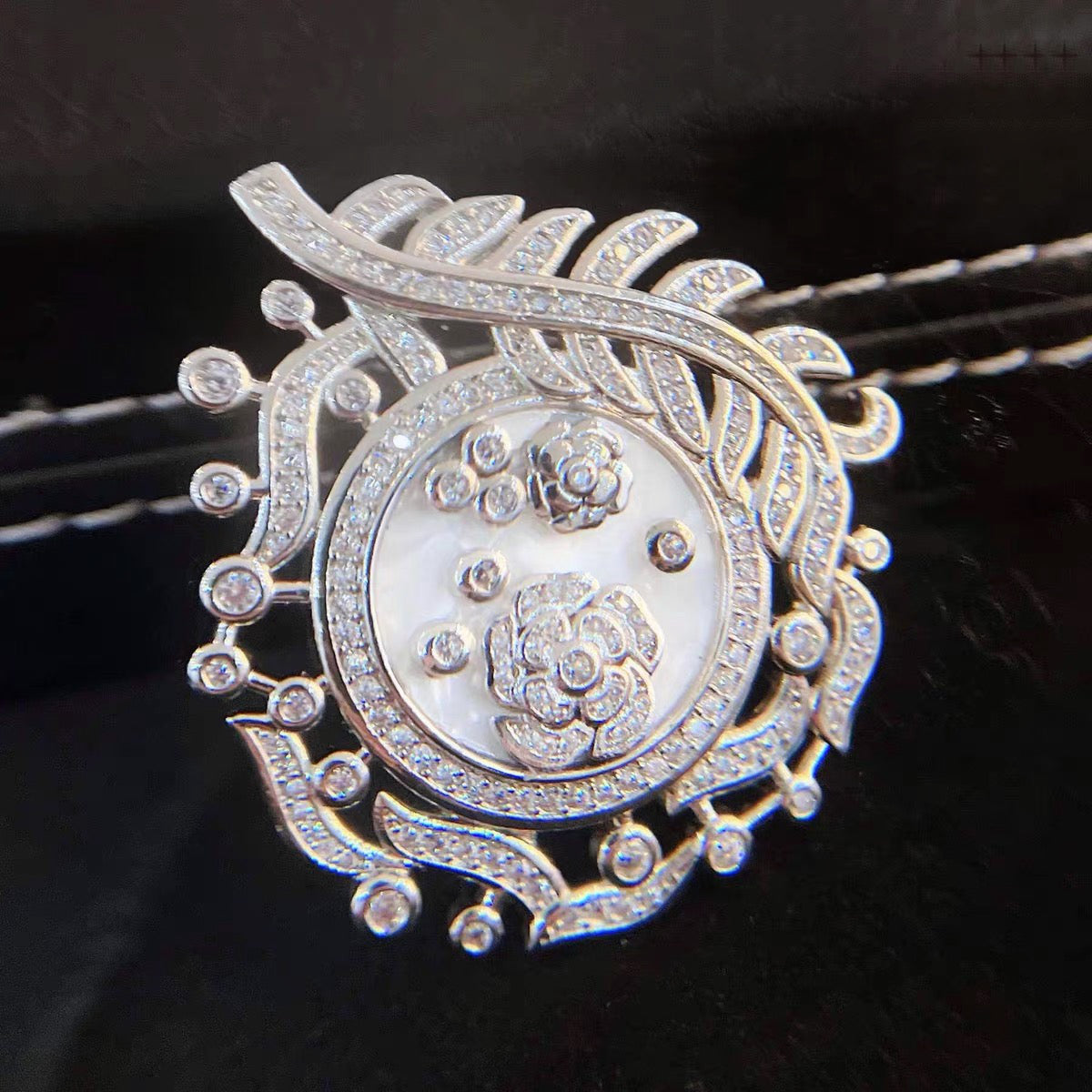 Camellia Convertible Watch Style Bracelet featuring a detachable mother-of-pearl and premium-grade zirconia centerpiece on a black PU leather strap with a luxurious watch-inspired design.