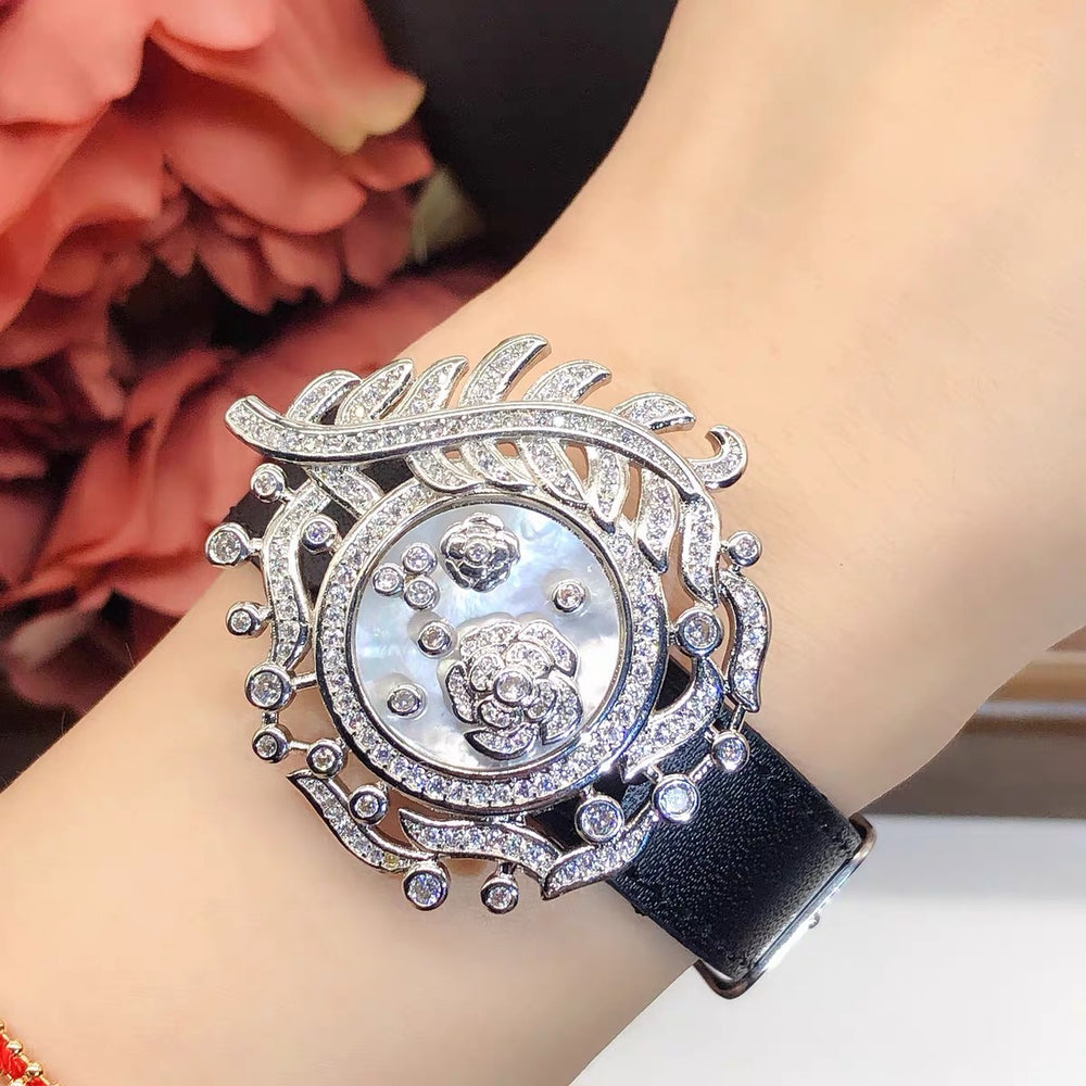 Camellia Convertible Watch Style Bracelet featuring a detachable mother-of-pearl and premium-grade zirconia centerpiece on a black PU leather strap with a luxurious watch-inspired design.