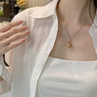 Luxe Carousel Pearl Pendant Necklace featuring a luminous pearl suspended inside an intricately detailed carousel pendant with sparkling accents and a gold-tone finish on a 40 + 5 cm chain.