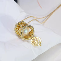 Luxe Carousel Pearl Pendant Necklace featuring a luminous pearl suspended inside an intricately detailed carousel pendant with sparkling accents and a gold-tone finish on a 40 + 5 cm chain.