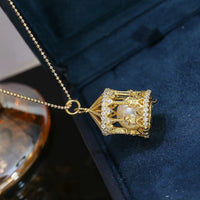 Luxe Carousel Pearl Pendant Necklace featuring a luminous pearl suspended inside an intricately detailed carousel pendant with sparkling accents and a gold-tone finish on a 40 + 5 cm chain.