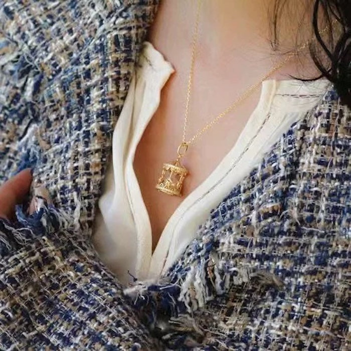 Luxe Carousel Pearl Pendant Necklace featuring a luminous pearl suspended inside an intricately detailed carousel pendant with sparkling accents and a gold-tone finish on a 40 + 5 cm chain.