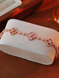 Blooming Clover Charm Bracelet featuring clover blossom charms accented with sparkling stones and an adjustable slider clasp.