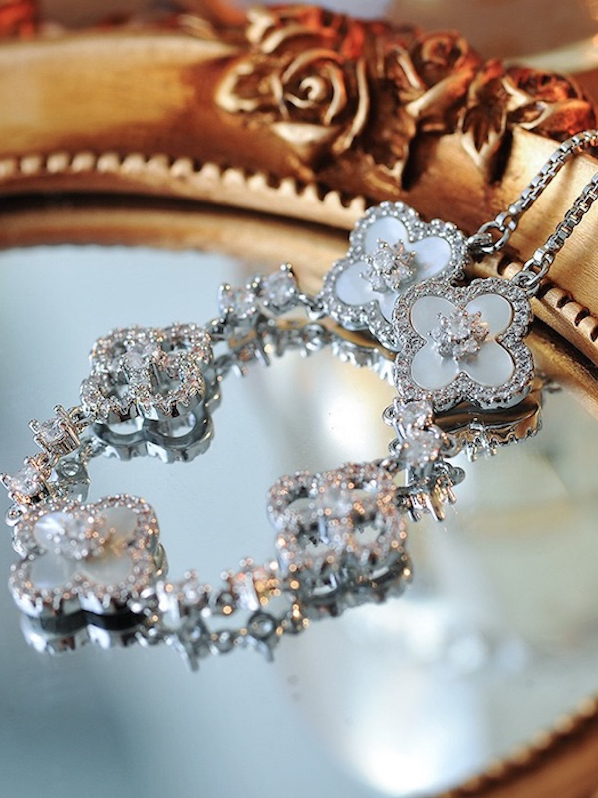 Blooming Clover Charm Bracelet featuring clover blossom charms accented with sparkling stones and an adjustable slider clasp.