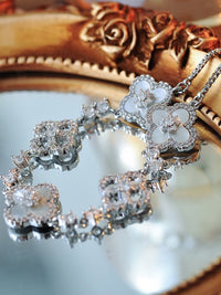 Blooming Clover Charm Bracelet featuring clover blossom charms accented with sparkling stones and an adjustable slider clasp.