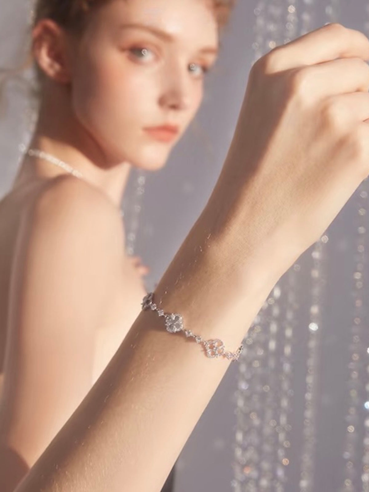 Blooming Clover Charm Bracelet featuring clover blossom charms accented with sparkling stones and an adjustable slider clasp.