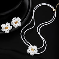 Handmade Daisy Beaded Necklace and Earrings Set featuring handwoven white daisy flowers with gold-tone accents, a 76 cm beaded necklace, and matching floral earrings.