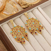Vintage Dream Catcher Drop Earrings featuring intricate gold-tone openwork details with red and turquoise crystal accents in a statement drop design.
