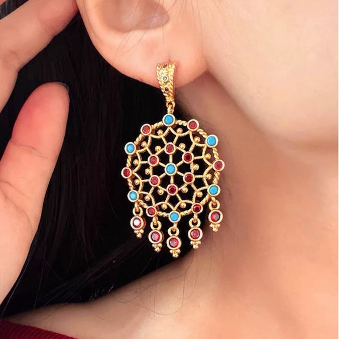 Vintage Dream Catcher Drop Earrings featuring intricate gold-tone openwork details with red and turquoise crystal accents in a statement drop design.

