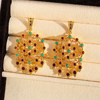 Vintage Dream Catcher Drop Earrings featuring intricate gold-tone openwork details with red and turquoise crystal accents in a statement drop design.
