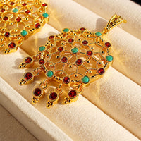 Vintage Dream Catcher Drop Earrings featuring intricate gold-tone openwork details with red and turquoise crystal accents in a statement drop design.
