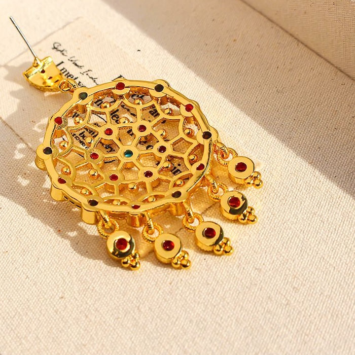 Vintage Dream Catcher Drop Earrings featuring intricate gold-tone openwork details with red and turquoise crystal accents in a statement drop design.
