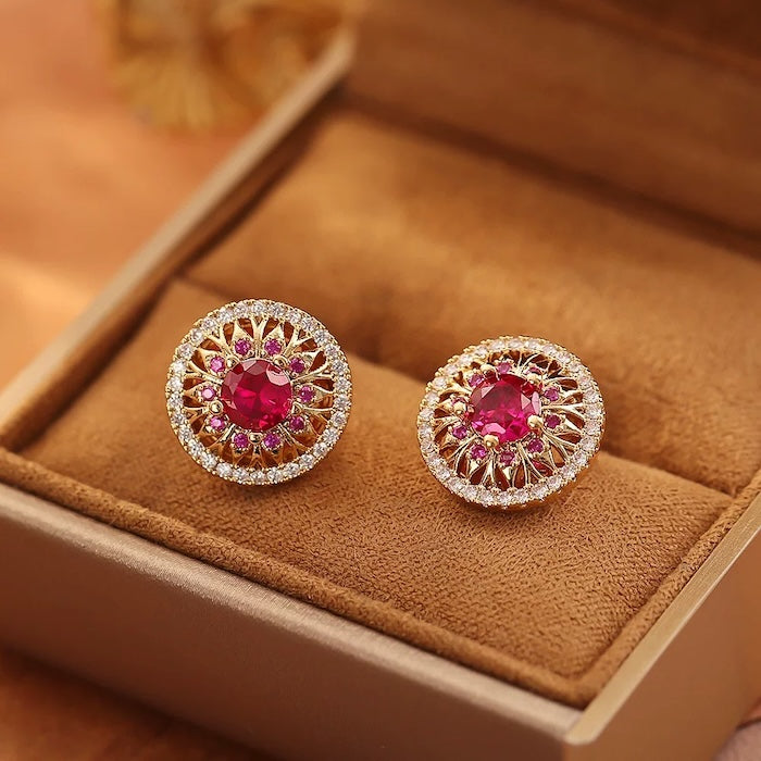 Vintage Style Halo Crystal Stud Earrings featuring a sparkling halo of zirconias surrounding a ruby red or sky blue center stone in a gold-tone vintage-inspired setting.
