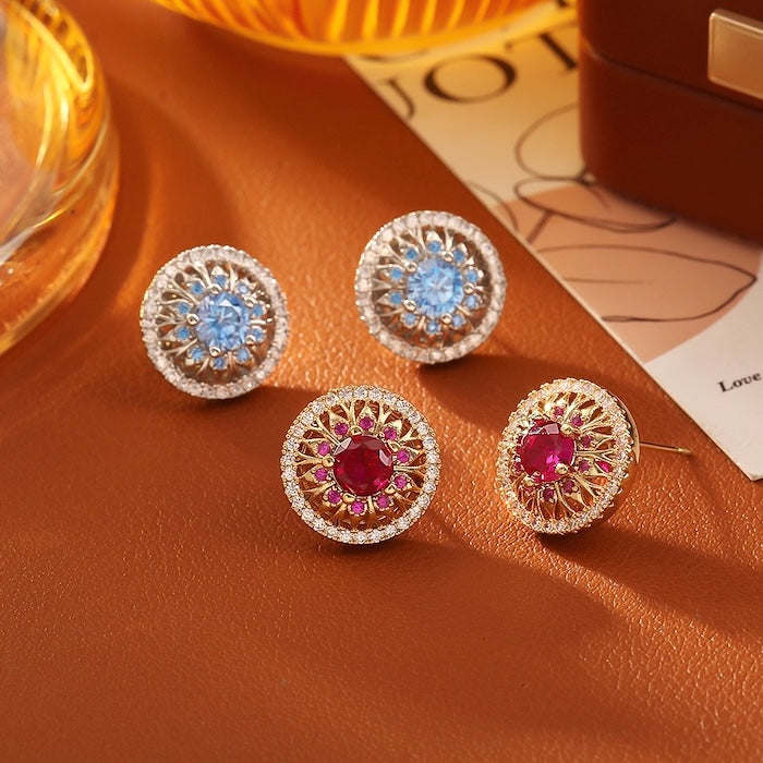 Vintage Style Halo Crystal Stud Earrings featuring a sparkling halo of zirconias surrounding a ruby red or sky blue center stone in a gold-tone vintage-inspired setting.
