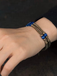 Lapis Lazuli Square Bead Bracelet featuring genuine deep-blue lapis lazuli square beads, layered bronze-toned bangles, and a vintage-inspired charm.