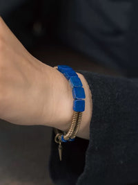 Lapis Lazuli Square Bead Bracelet featuring genuine deep-blue lapis lazuli square beads, layered bronze-toned bangles, and a vintage-inspired charm.