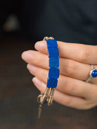Lapis Lazuli Square Bead Bracelet featuring genuine deep-blue lapis lazuli square beads, layered bronze-toned bangles, and a vintage-inspired charm.
