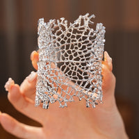 Gilded Leaf Vein Cuff Bracelet with an intricate leaf vein-inspired openwork design in gold-plated or silver-tone alloy featuring a wide sculptural silhouette.