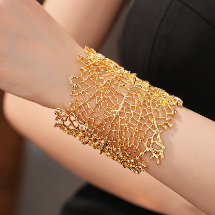 Gilded Leaf Vein Cuff Bracelet with an intricate leaf vein-inspired openwork design in gold-plated or silver-tone alloy featuring a wide sculptural silhouette.