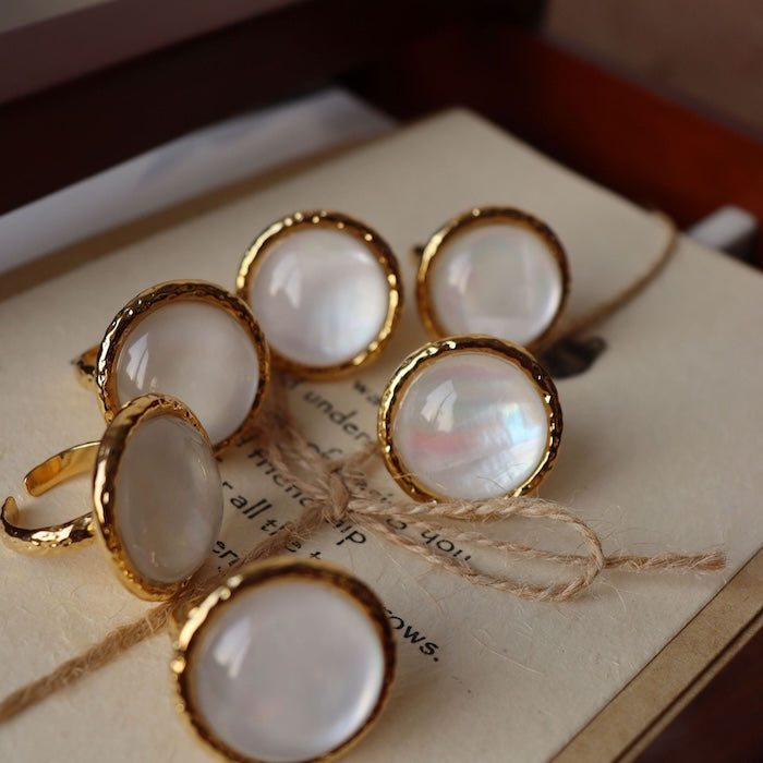 Vintage Mother of Pearl Dome Ring featuring a large round mother-of-pearl cabochon in a textured gold-tone adjustable setting worn as a statement ring.
