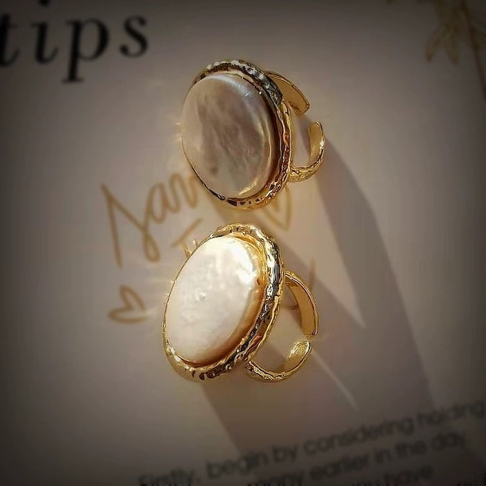 Vintage Mother of Pearl Dome Ring featuring a large round mother-of-pearl cabochon in a textured gold-tone adjustable setting worn as a statement ring.
