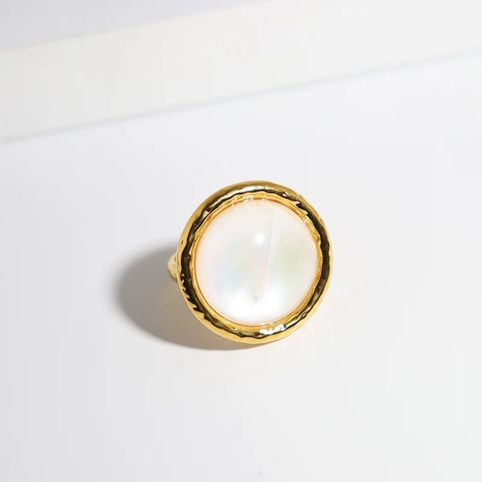 Vintage Mother of Pearl Dome Ring featuring a large round mother-of-pearl cabochon in a textured gold-tone adjustable setting worn as a statement ring.
