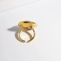 Vintage Mother of Pearl Dome Ring featuring a large round mother-of-pearl cabochon in a textured gold-tone adjustable setting worn as a statement ring.
