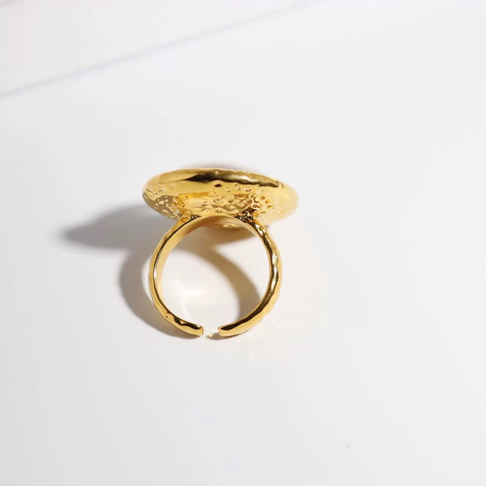 Vintage Mother of Pearl Dome Ring featuring a large round mother-of-pearl cabochon in a textured gold-tone adjustable setting worn as a statement ring.
