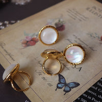 Vintage Mother of Pearl Dome Ring featuring a large round mother-of-pearl cabochon in a textured gold-tone adjustable setting worn as a statement ring.
