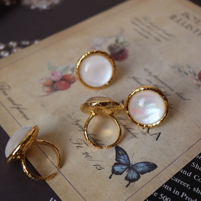 Vintage Mother of Pearl Dome Ring featuring a large round mother-of-pearl cabochon in a textured gold-tone adjustable setting worn as a statement ring.
