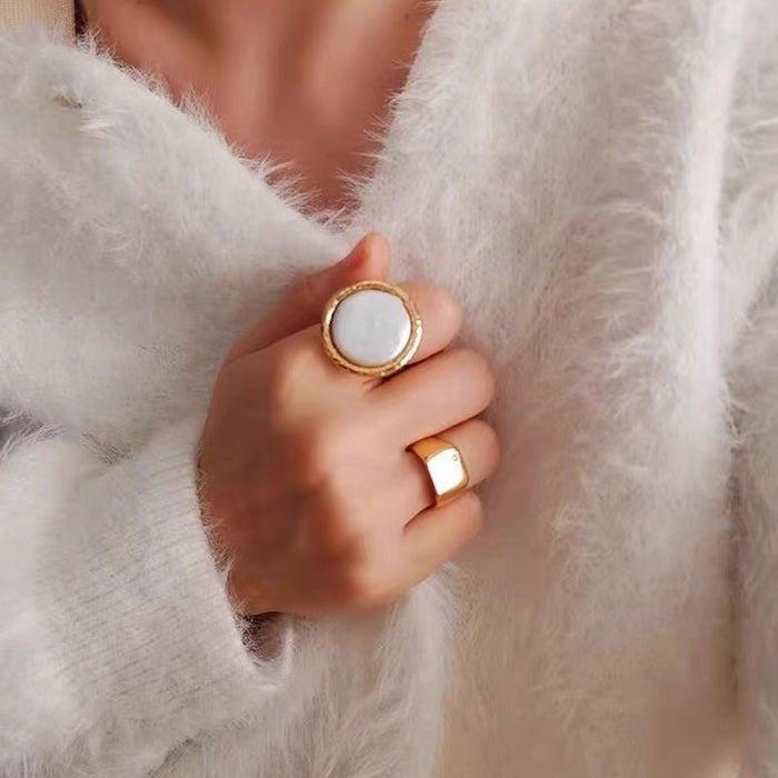 Vintage Mother of Pearl Dome Ring featuring a large round mother-of-pearl cabochon in a textured gold-tone adjustable setting worn as a statement ring.
