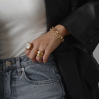 Vintage Mother of Pearl Dome Ring featuring a large round mother-of-pearl cabochon in a textured gold-tone adjustable setting worn as a statement ring.
