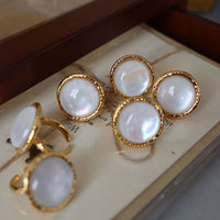 Vintage Mother of Pearl Dome Ring featuring a large round mother-of-pearl cabochon in a textured gold-tone adjustable setting worn as a statement ring.

