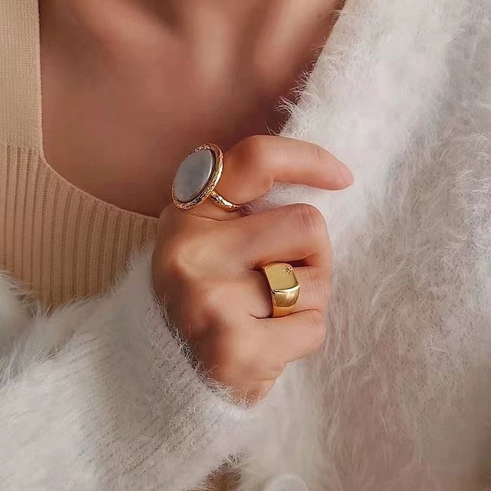 Vintage Mother of Pearl Dome Ring featuring a large round mother-of-pearl cabochon in a textured gold-tone adjustable setting worn as a statement ring.
