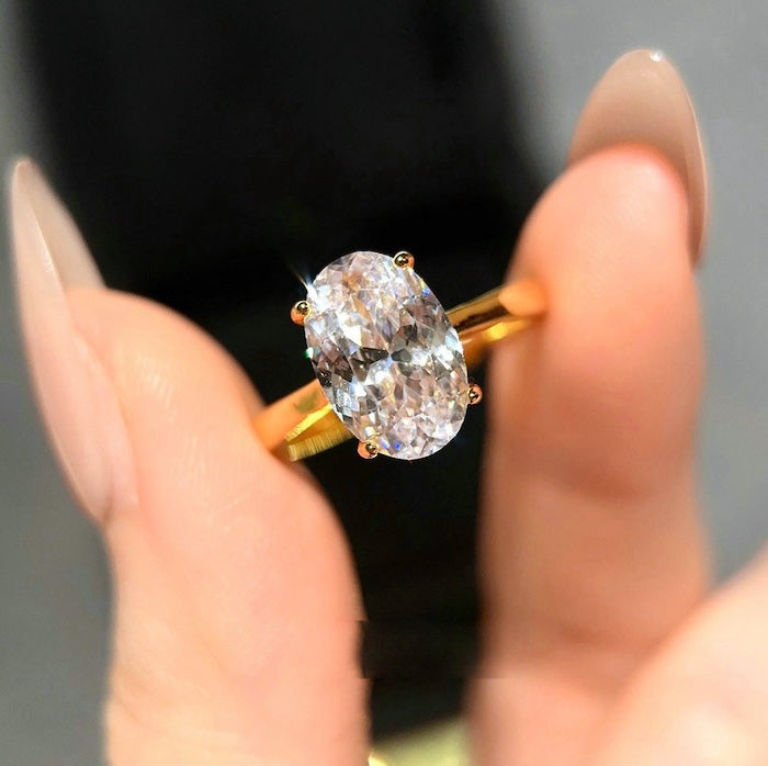 Dazzling 5CT Pigeon Egg Oval Stone Ring featuring a large oval-cut premium zirconia in a gold-plated adjustable solitaire-inspired setting.
