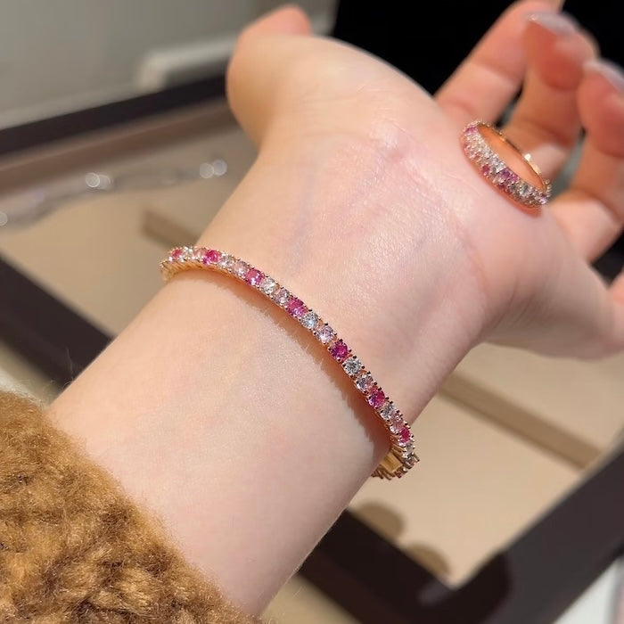 Dazzling Pink Ombré Tennis Bracelet featuring sparkling pink and clear zirconias in a gradient tennis bracelet design, available in two stone sizes.
