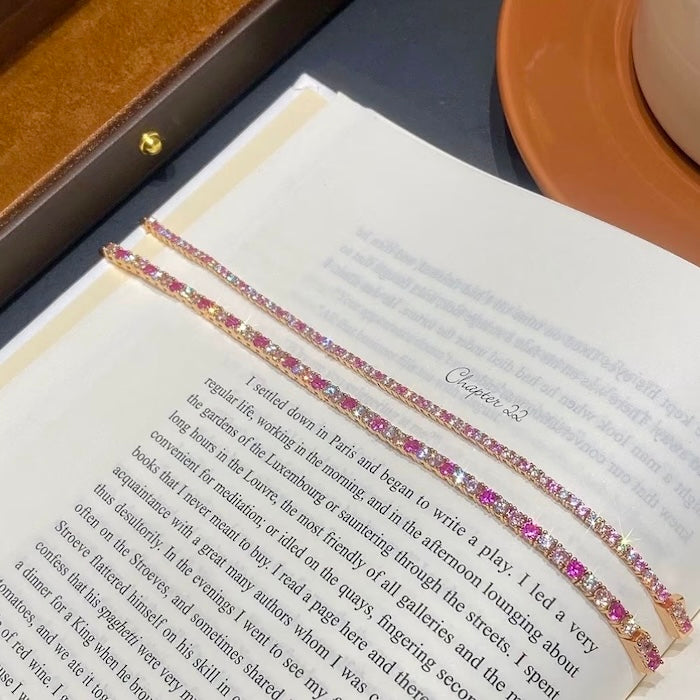 Dazzling Pink Ombré Tennis Bracelet featuring sparkling pink and clear zirconias in a gradient tennis bracelet design, available in two stone sizes.
