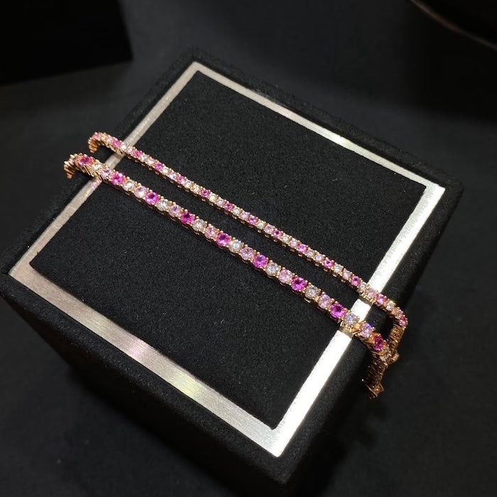 Dazzling Pink Ombré Tennis Bracelet featuring sparkling pink and clear zirconias in a gradient tennis bracelet design, available in two stone sizes.
