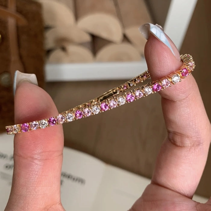 Dazzling Pink Ombré Tennis Bracelet featuring sparkling pink and clear zirconias in a gradient tennis bracelet design, available in two stone sizes.
