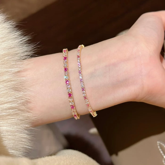 Dazzling Pink Ombré Tennis Bracelet featuring sparkling pink and clear zirconias in a gradient tennis bracelet design, available in two stone sizes.
