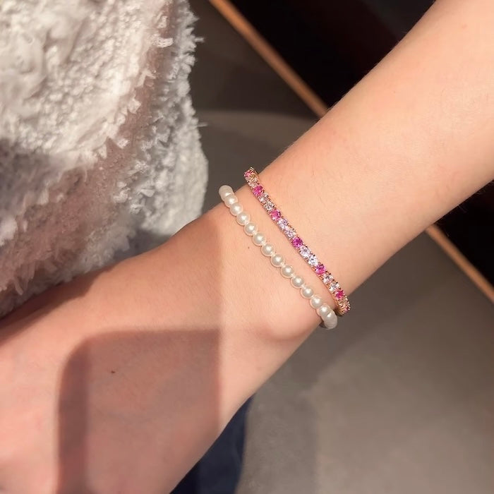 Dazzling Pink Ombré Tennis Bracelet featuring sparkling pink and clear zirconias in a gradient tennis bracelet design, available in two stone sizes.
