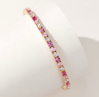 Dazzling Pink Ombré Tennis Bracelet featuring sparkling pink and clear zirconias in a gradient tennis bracelet design, available in two stone sizes.
