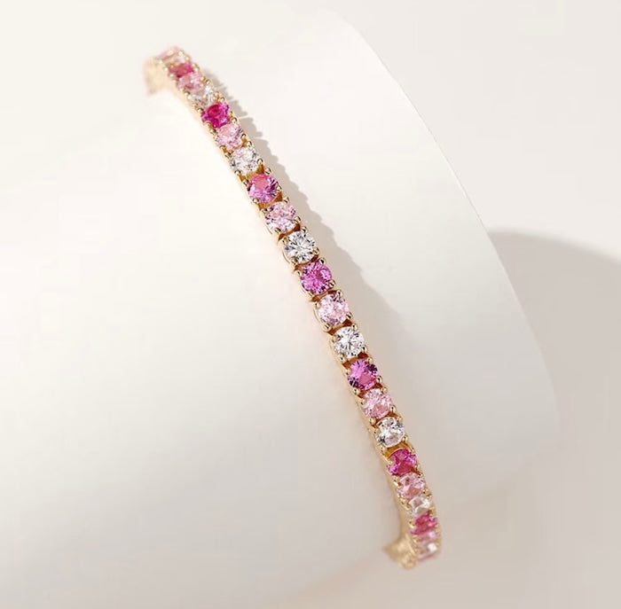 Dazzling Pink Ombré Tennis Bracelet featuring sparkling pink and clear zirconias in a gradient tennis bracelet design, available in two stone sizes.
