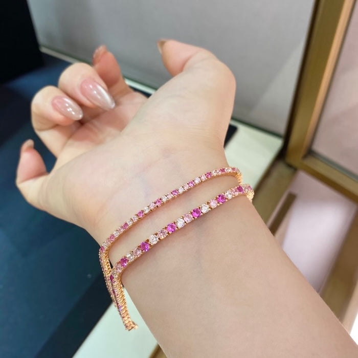 Dazzling Pink Ombré Tennis Bracelet featuring sparkling pink and clear zirconias in a gradient tennis bracelet design, available in two stone sizes.
