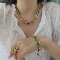 Vintage Rainbow Glass Stones Jewelry Set featuring multicolor glass stones in green, blue, pink, and amber tones linked in a gold-tone vintage-inspired necklace and bracelet design.
