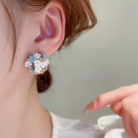 Blooming Rose Bouquet Ceramic Earrings featuring handcrafted ceramic roses, sparkling crystal accents, and rose gold-plated brass. Available in lilac or light blue for timeless vintage-inspired elegance.