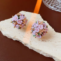 Blooming Rose Bouquet Ceramic Earrings featuring handcrafted ceramic roses, sparkling crystal accents, and rose gold-plated brass. Available in lilac or light blue for timeless vintage-inspired elegance.